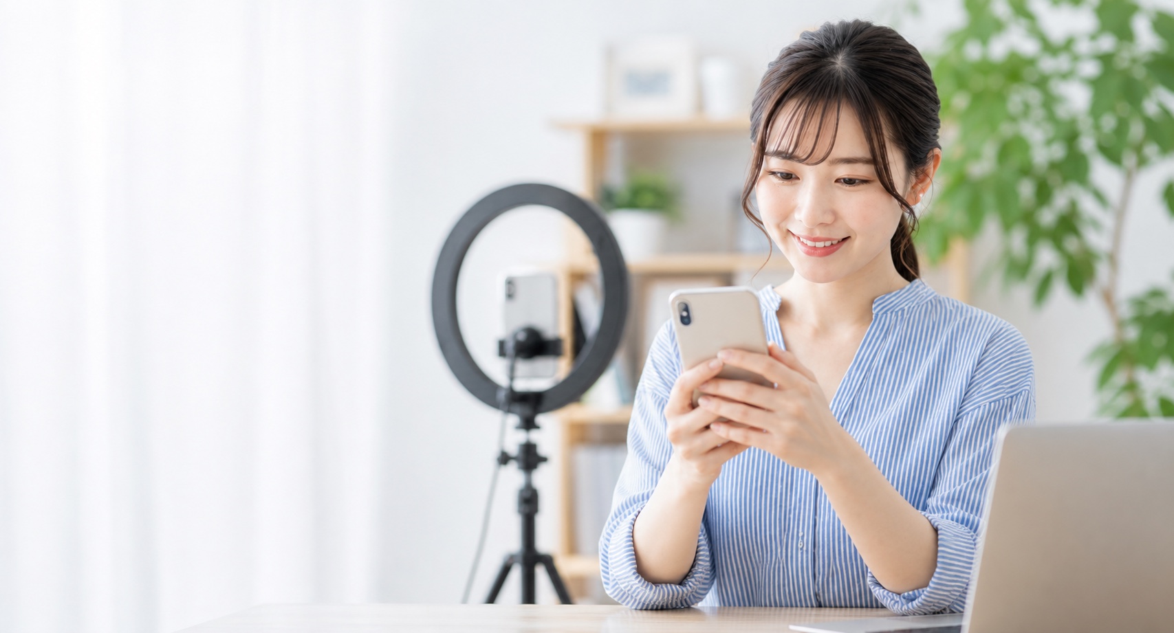 スマートフォンでSNS運用を行う女性